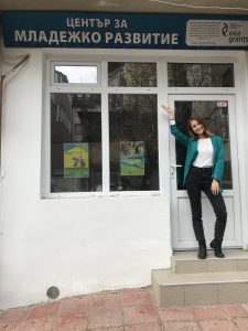 Доброволка стои пред офис на неправителствена организация