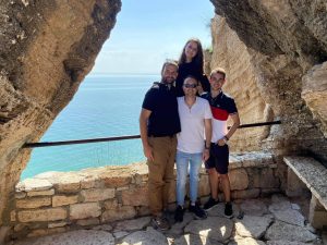 A group of volunteers smiling in front of the sea